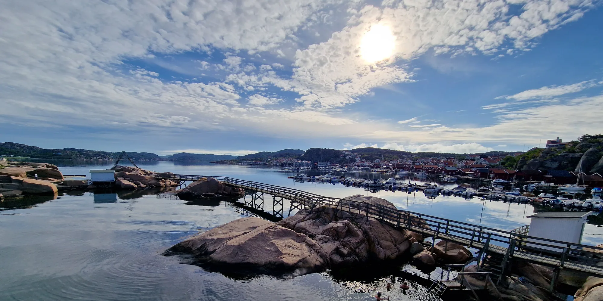Die Sonne über den Brücken zwischen den Inseln, dahinter die Klippen und der Hafen